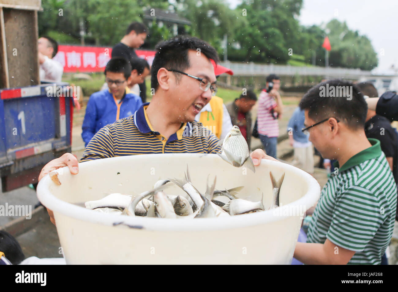 (170606) -- CHANGSHA, June 6, 2017 (Xinhua) -- A volunteer carries fish fries to release into Xiangjiang River in Changsha, capital of central China's Hunan Province, June 6, 2017. 38.5 million fish fries were released into the Xiangjiang River on Tuesday.  (Xinhua/Wang Tiancong) (zwx) Stock Photo