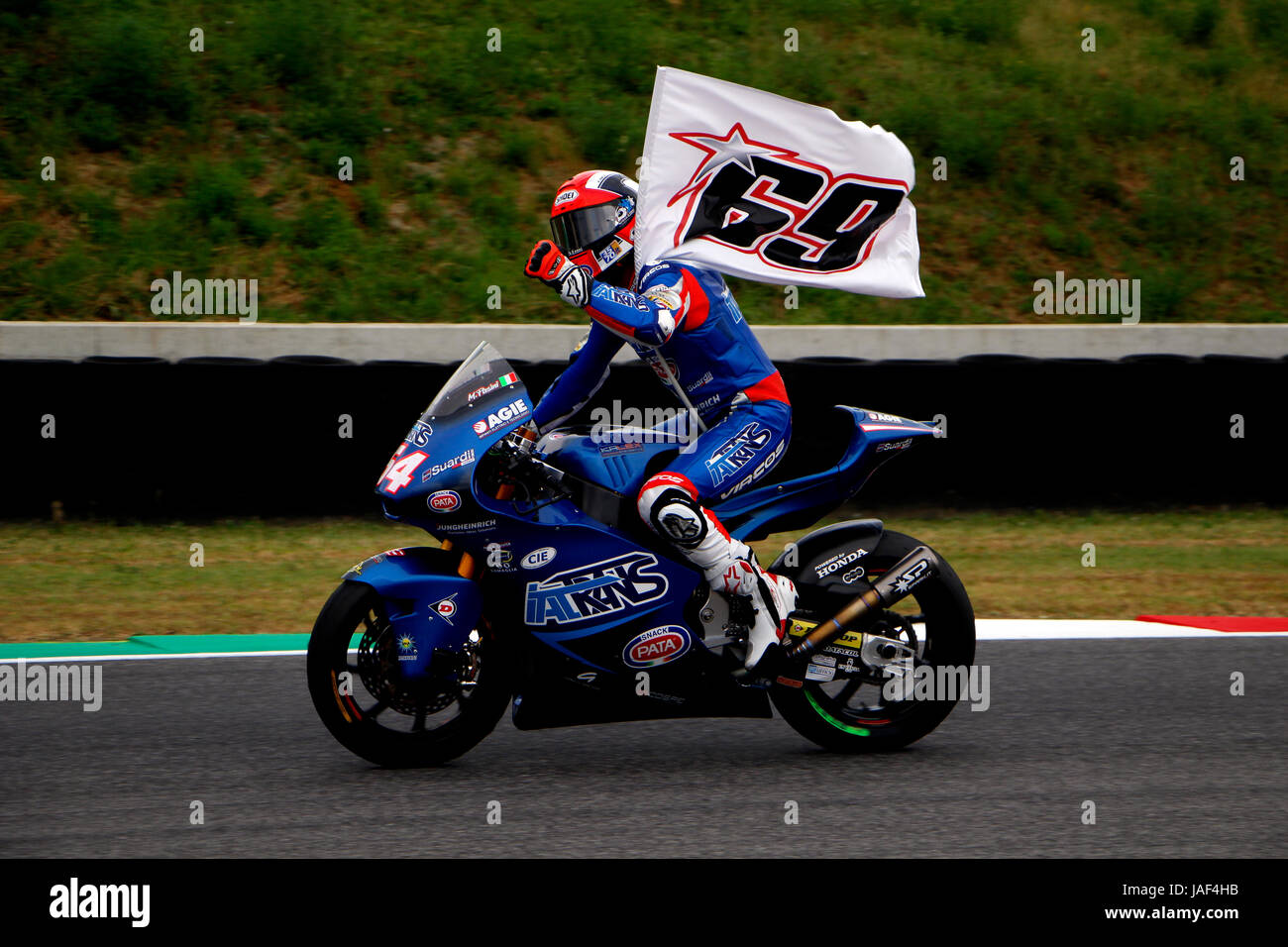 Florence, Italy. 04th June, 2017. Mattia Pasini pays tribute to Nicky Hayden whilst celebrating victory at the 2017 Italian Motorcycle Grand Prix. Moto2. Credit: Joseph Suschitzky/Alamy Live News Stock Photo