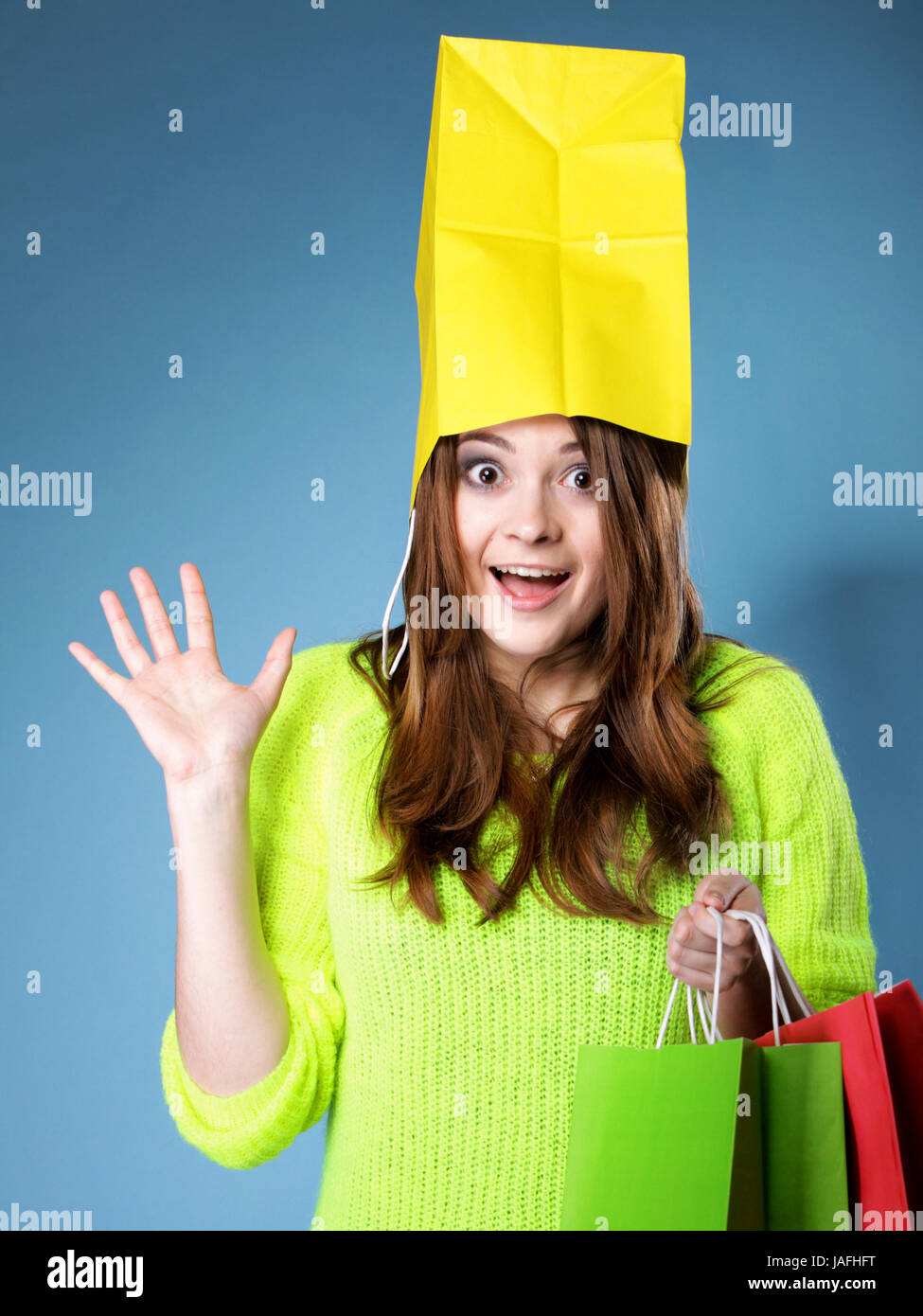 Surprised crazy woman bright vivid colour sweater with paper shopping