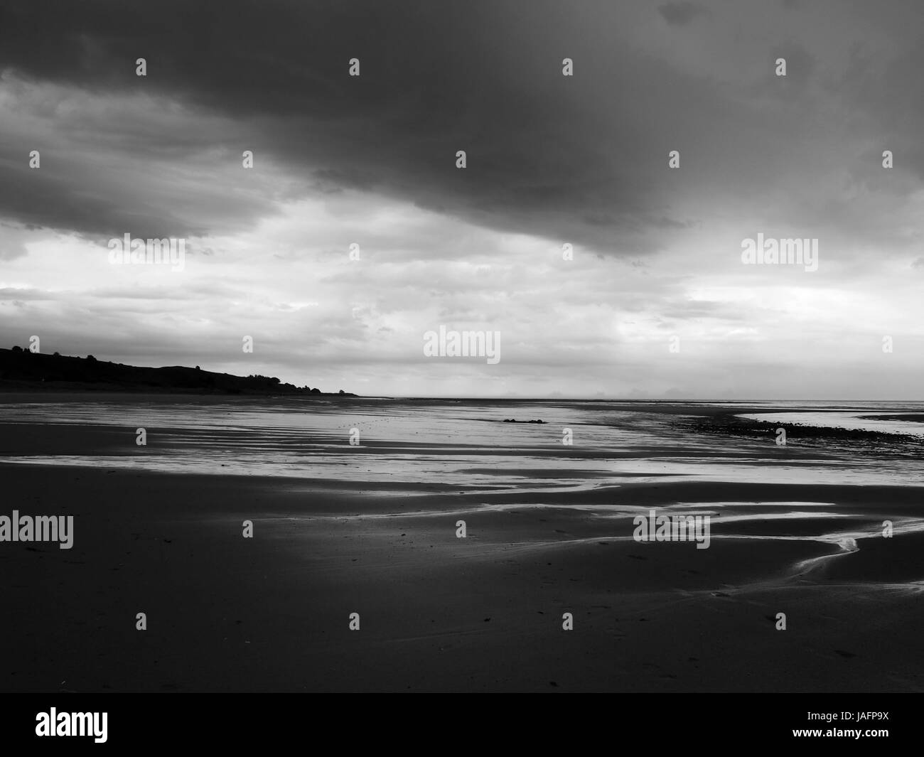 dark clouds and heavy storm on a beach in northumbria Stock Photo