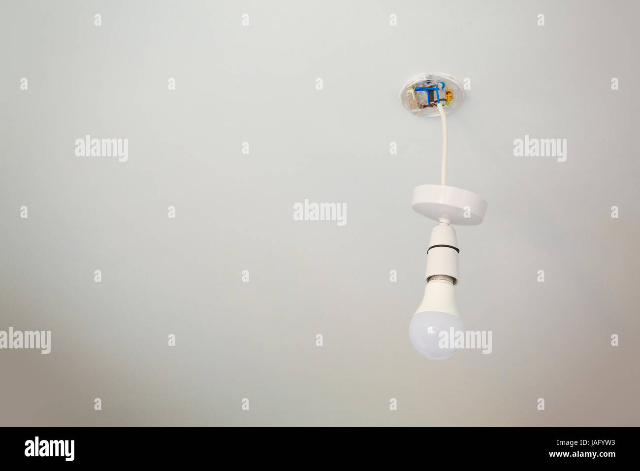 Low angle view of light fixture with light bulb hanging from a ceiling