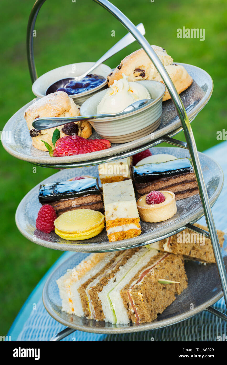 Close up of a cake stand with a selection of cakes and sandwiches, traditional afternoon tea. Stock Photo