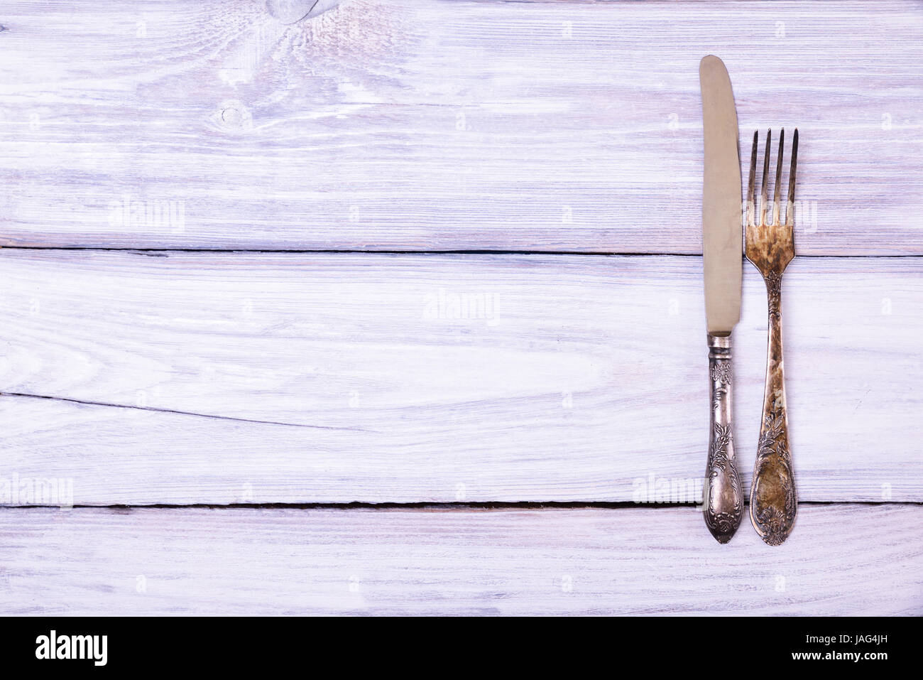 Iron fork and knife on a white wooden background, blank space Stock Photo