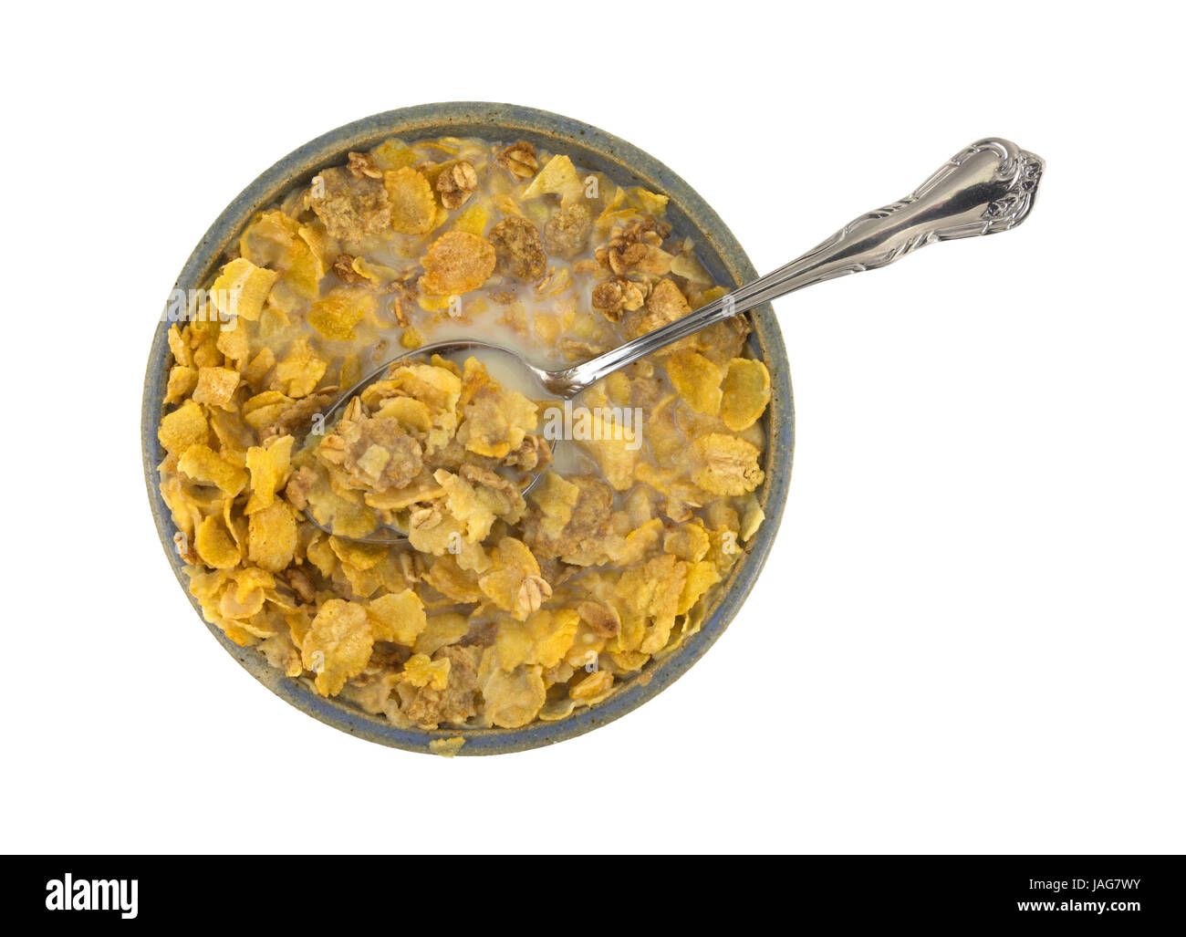 Top view of a bowl with multigrain breakfast cereal in skim milk with a spoon in the food isolated on a white background. Stock Photo