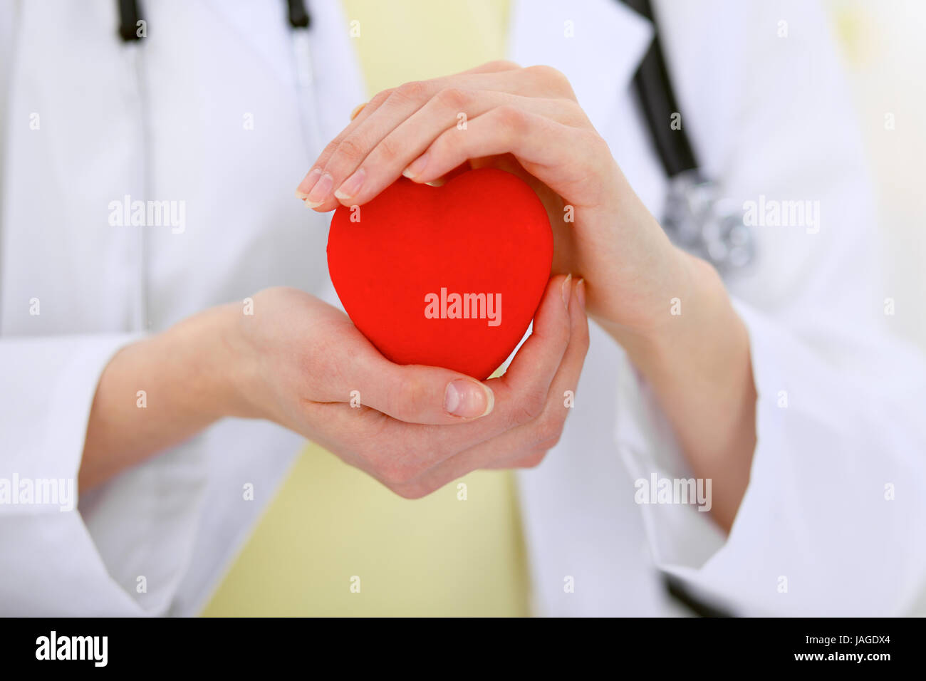 Female doctor with stethoscope holding heart Stock Photo - Alamy