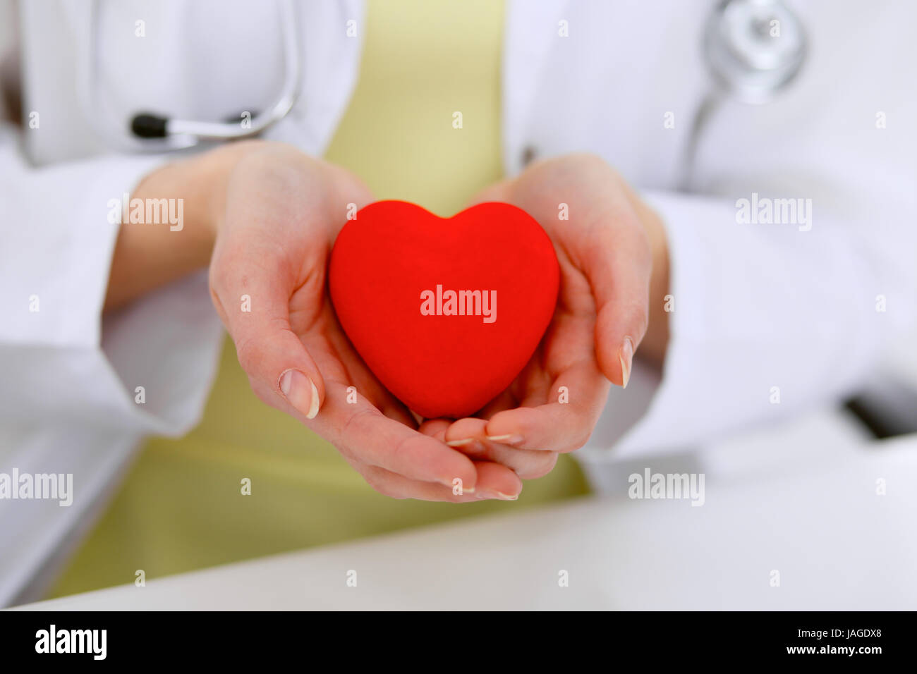 Female doctor with stethoscope holding heart Stock Photo - Alamy