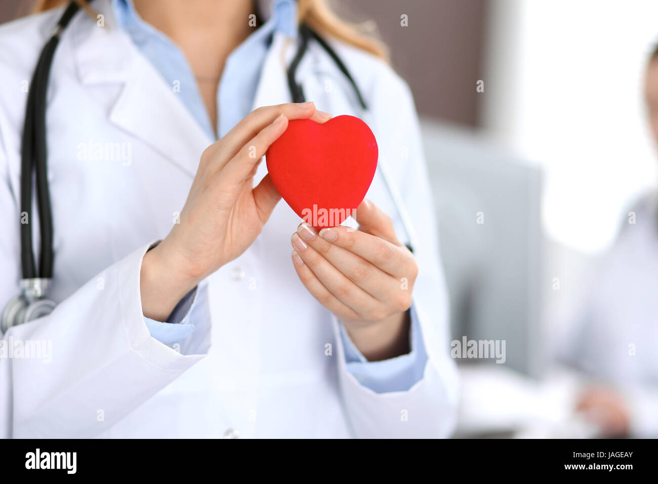 Female doctor with stethoscope holding heart Stock Photo - Alamy