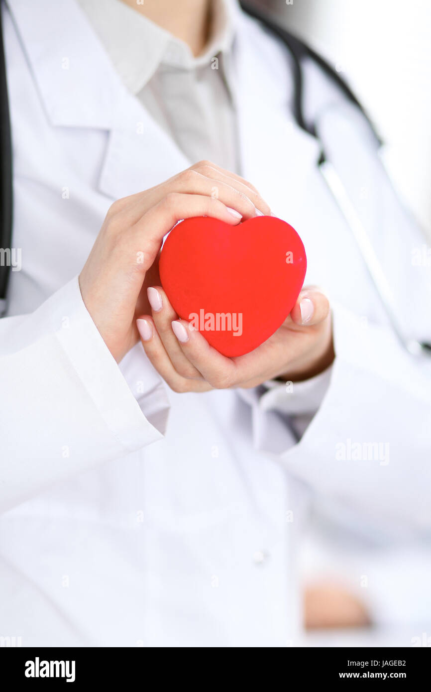 Female doctor with stethoscope holding heart Stock Photo - Alamy