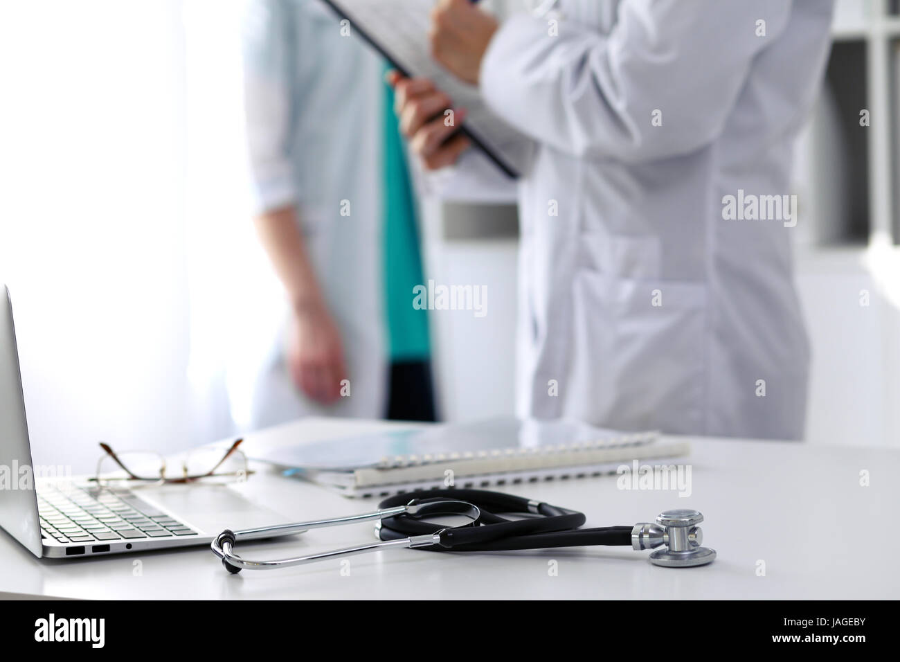 Medicine doctor's working table. Focus on stethoscope and laptop on