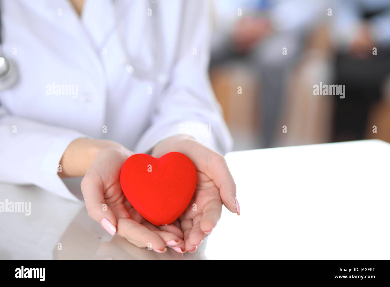 Female doctor with stethoscope holding heart Stock Photo - Alamy