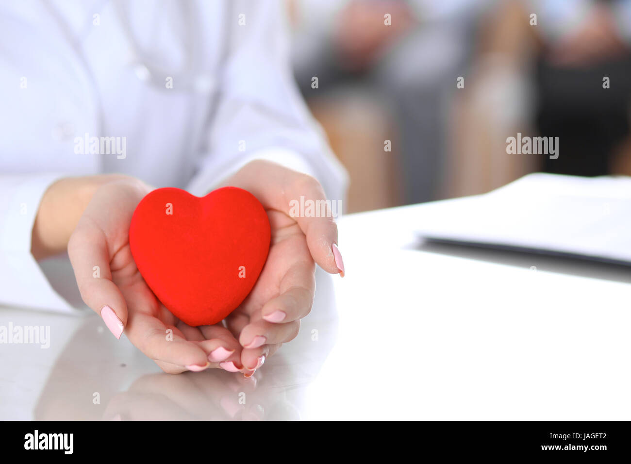 Female doctor with stethoscope holding heart Stock Photo - Alamy