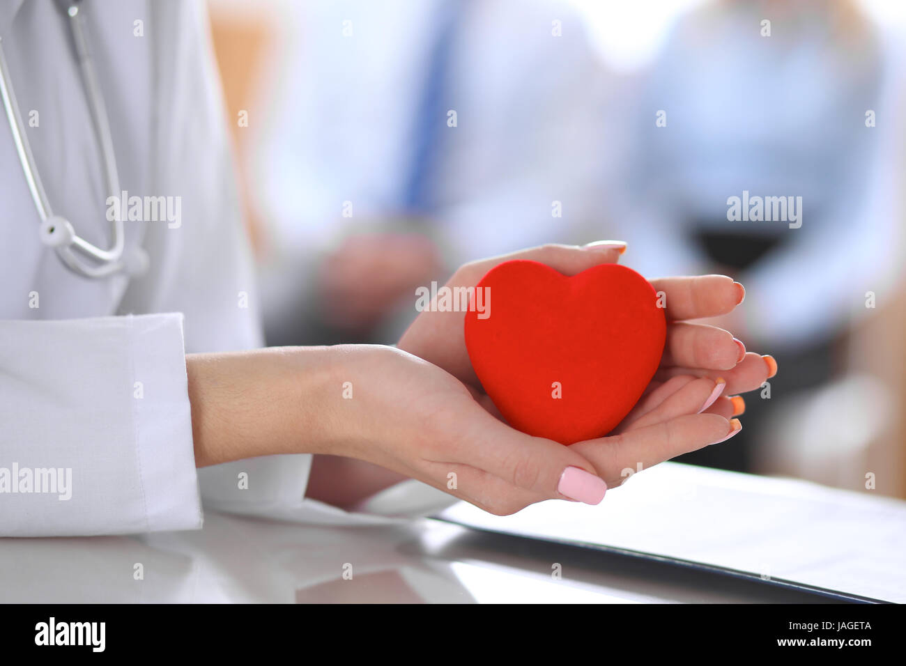 Female doctor with stethoscope holding heart Stock Photo - Alamy