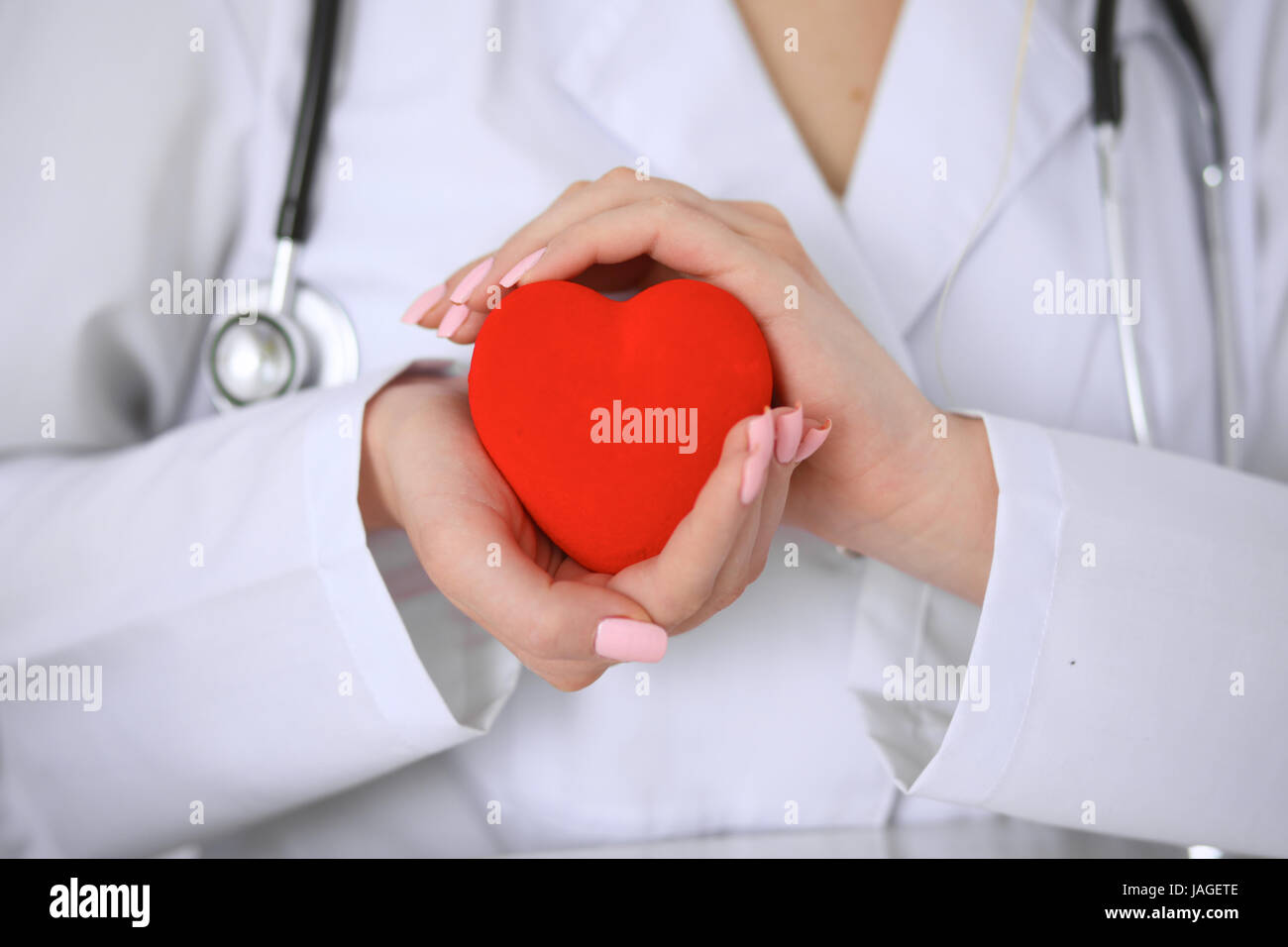 Female doctor with stethoscope holding heart Stock Photo - Alamy