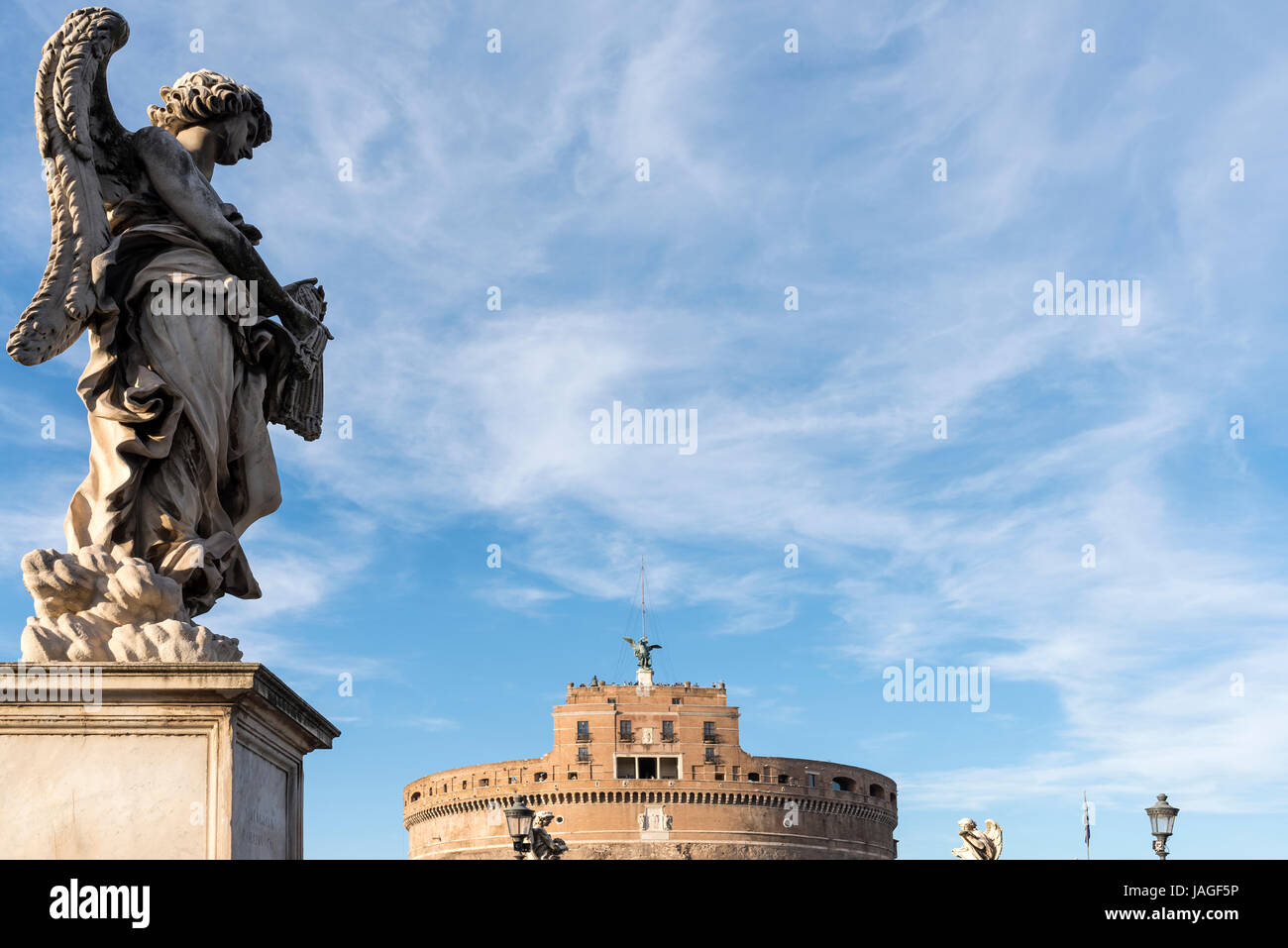 Statues of an Angel on the Pont Sant Angelo with the Castel Sant Angelo in the background, Rome, Italy Stock Photo