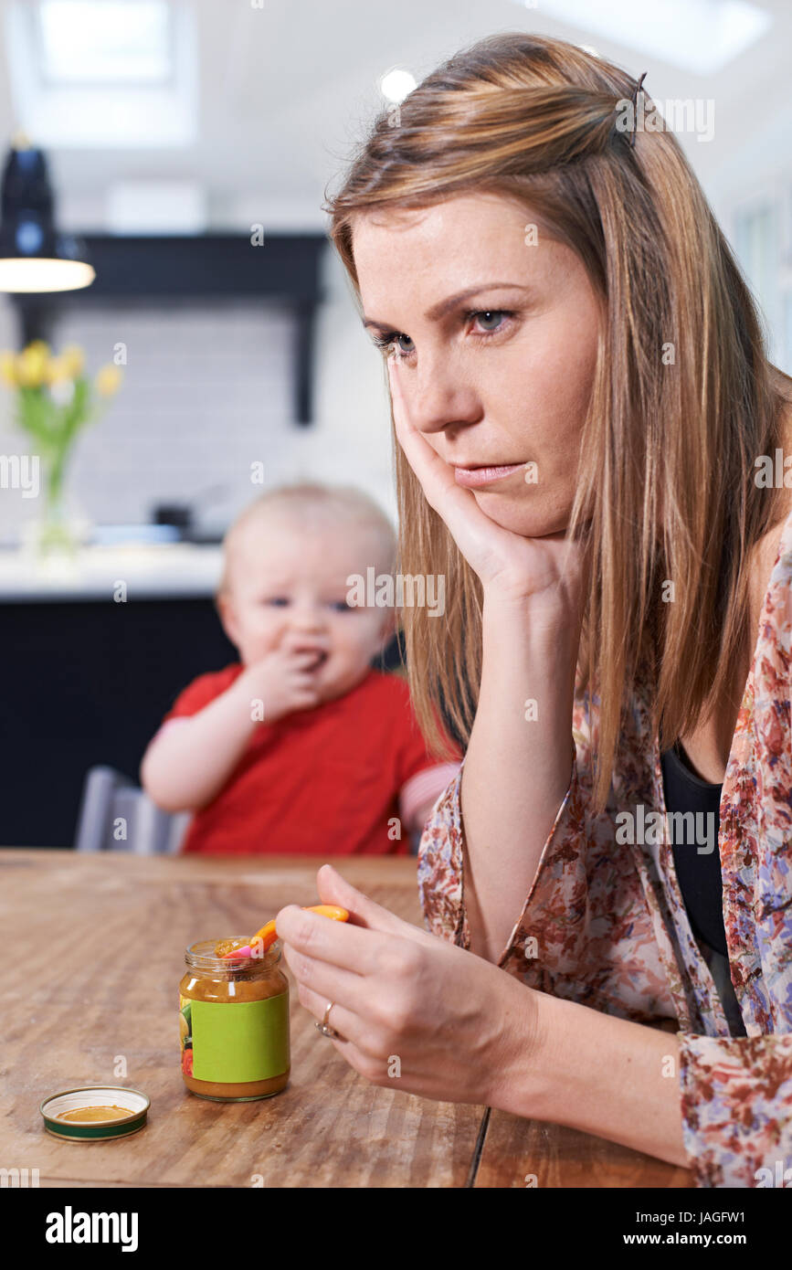Stressed Mother Trying To Feed Fussy Baby Stock Photo