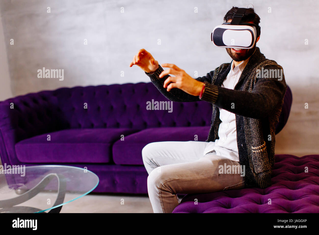 Closeup of bearded young man wearing virtual reality goggles in modern ...
