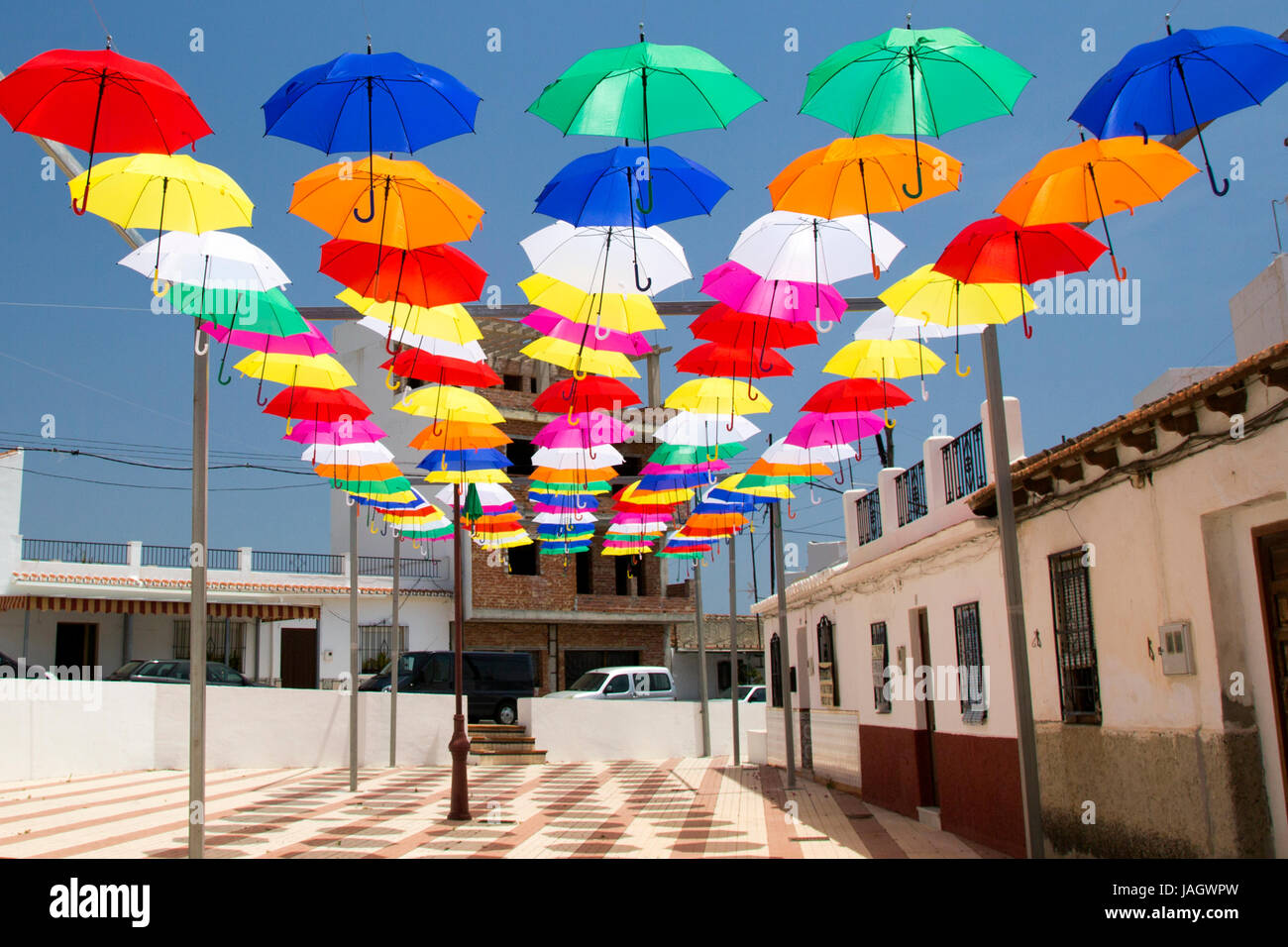 A display of brightly coloured umbrellas hanging above a street in