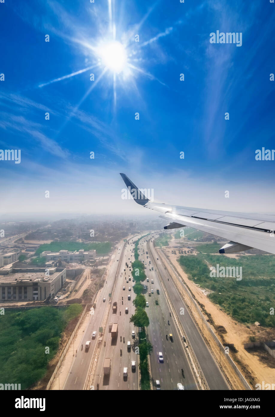 View through the window of a passenger plane flying above Delhi Gurgaon highway, taken just a minute before landing at the New Delhi Airport T3 termin Stock Photo