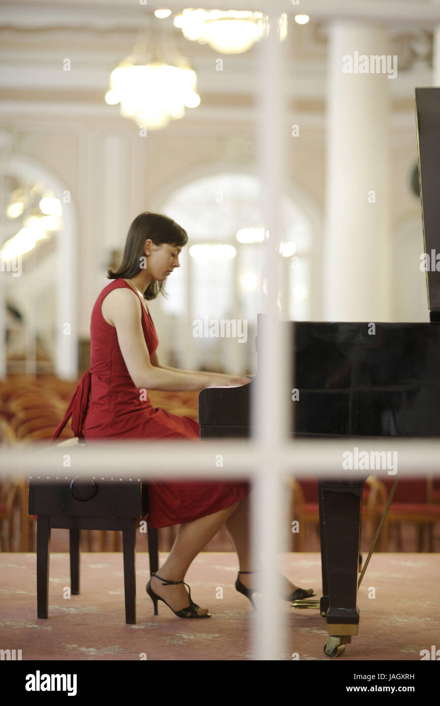 Woman in red dress plays the piano Stock Photo - Alamy