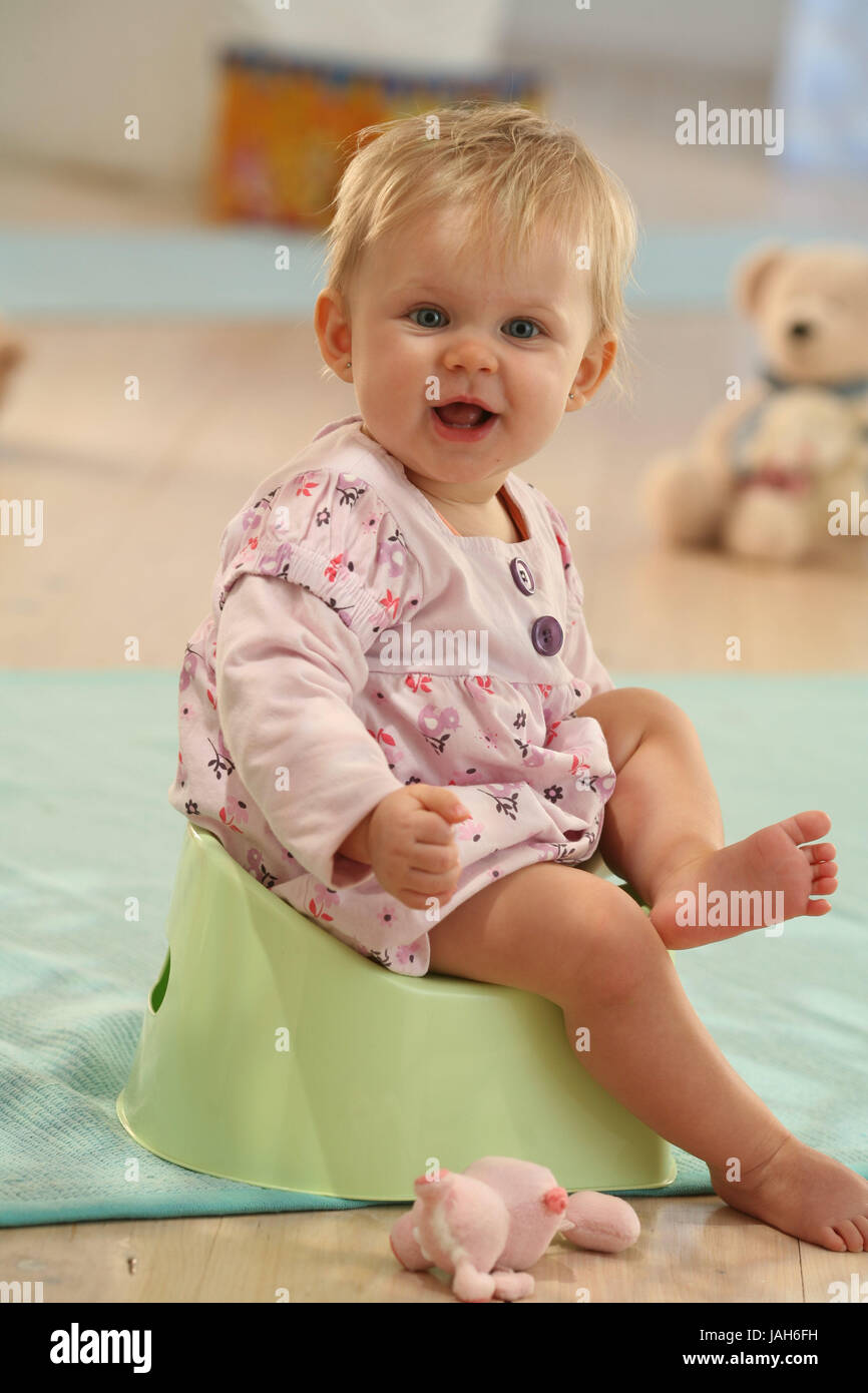 Baby,8 months,chamber pots,happily,layette,baby chamber pot,learning process,dresses,dress,pink,blond,Indoor,laugh,learn,girls,sit,joy,proudly, Stock Photo