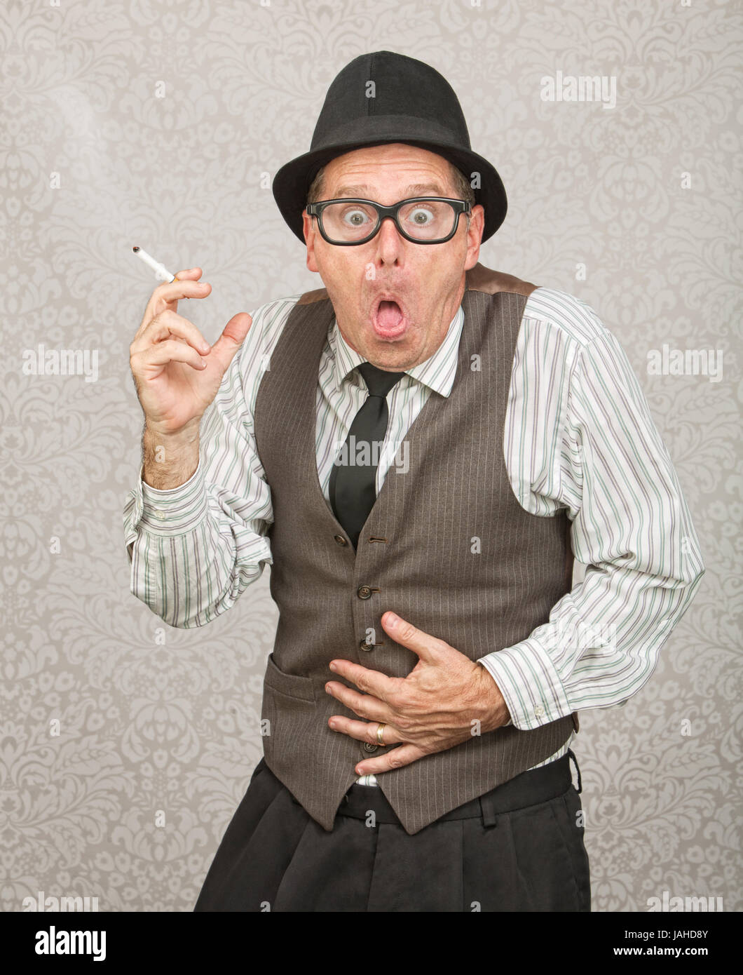 upset stomach after smoking cigarettes Single man holding cigarette with upset stomach Stock Photo