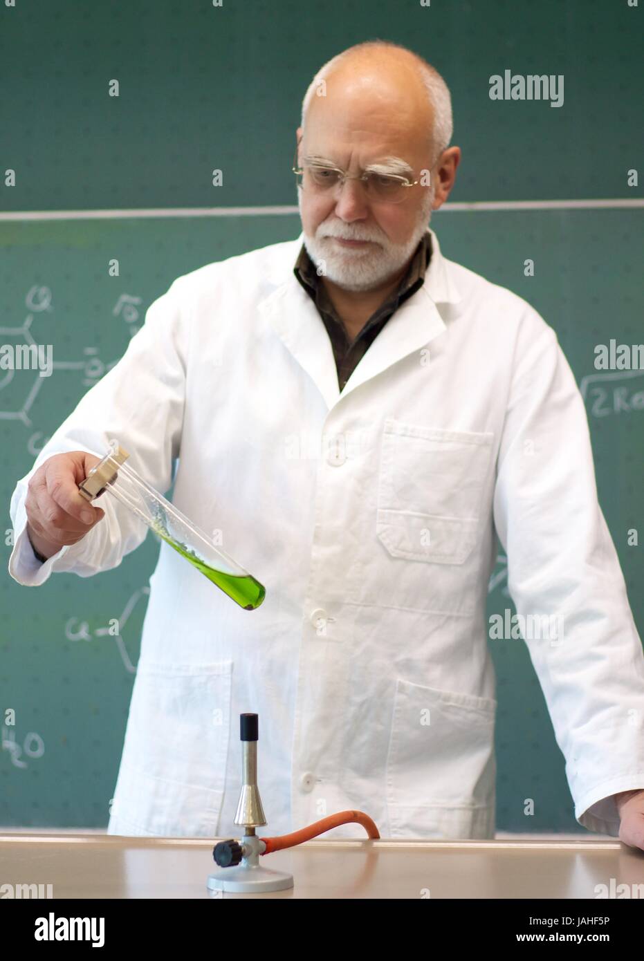 Lehrer erhitzt Chemikalien in einem Reagenzglas Stock Photo