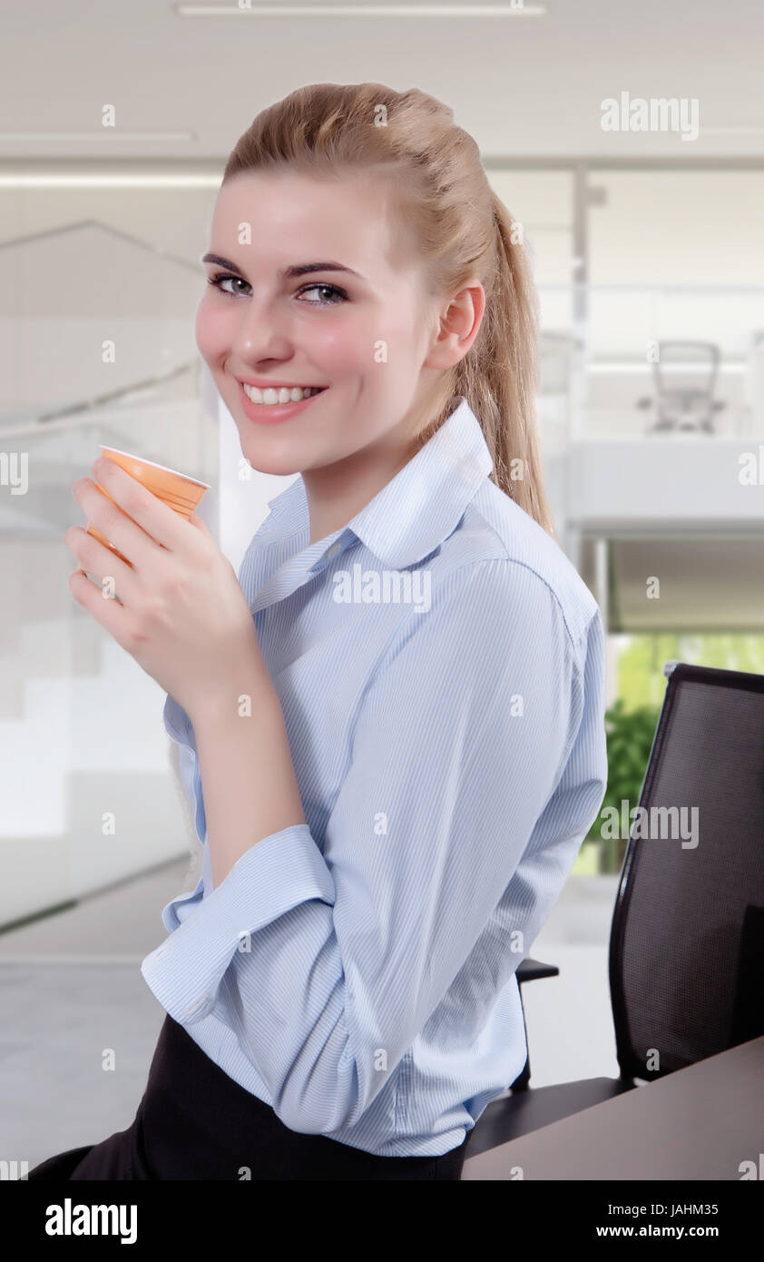 Successful business woman looking in the camera with a cup of coffee in ...