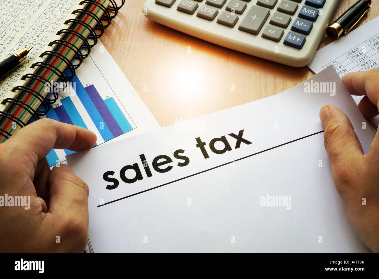 Hands holding documents with title sales tax. Stock Photo