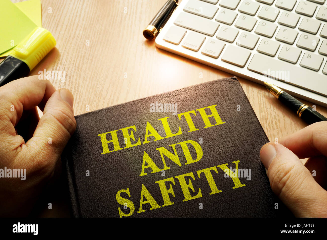 Hands holding documents with title health and safety. Stock Photo
