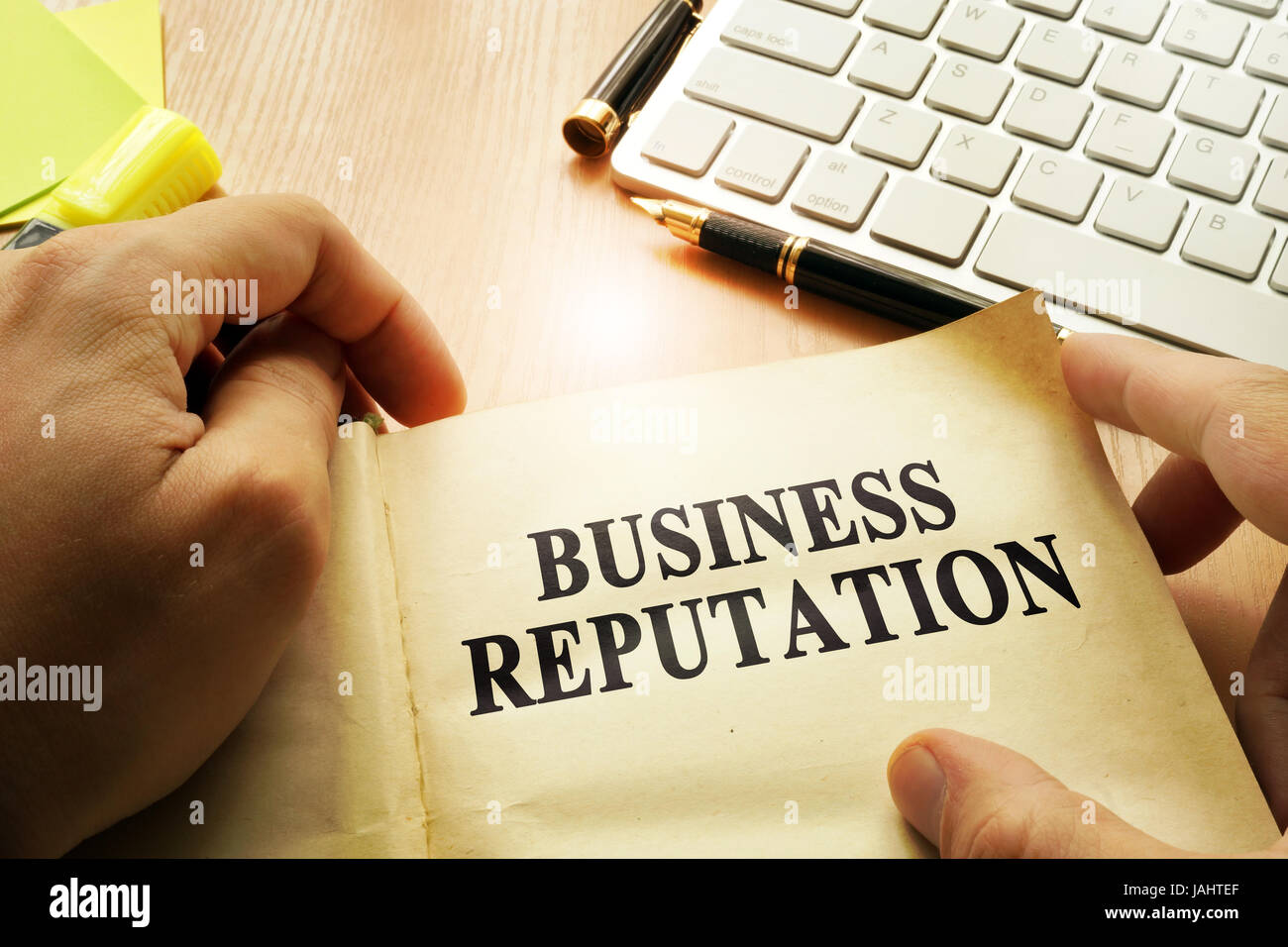 Hands holding documents with title Business Reputation. Stock Photo