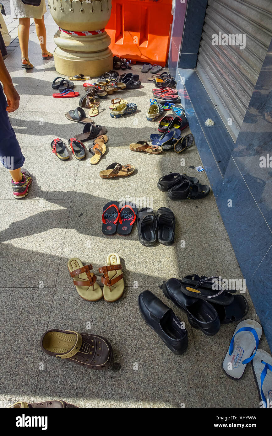 Kuala Lumpur, Malaysia - March 9, 2017: Shoes spread outside a Hindu temple, they have to be removed as a sign of respect before entering. Stock Photo