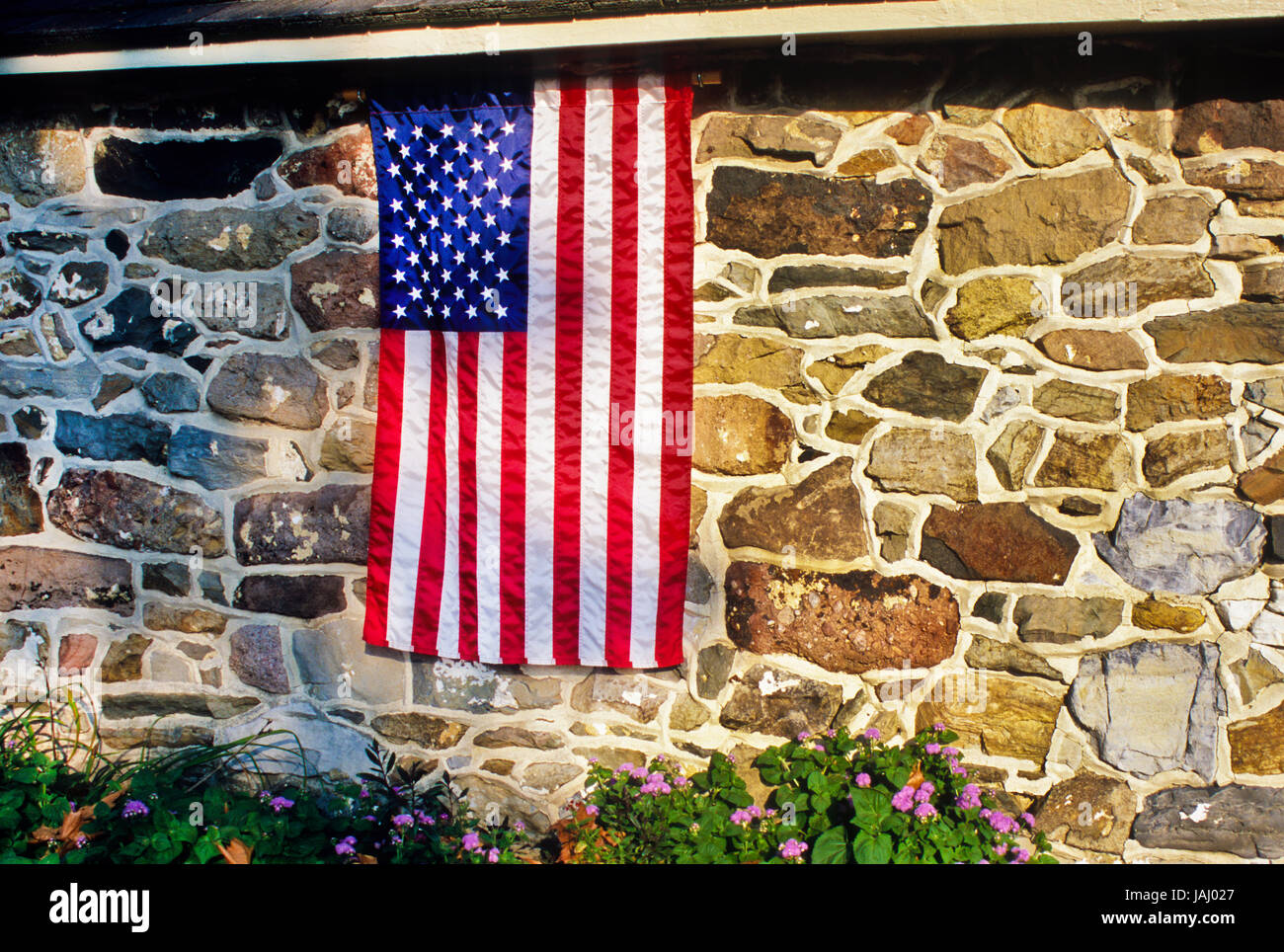 Isolated American flag on a stone spring house in Lancaster County, Pennsylvania, USA, close up US flag Stock Photo