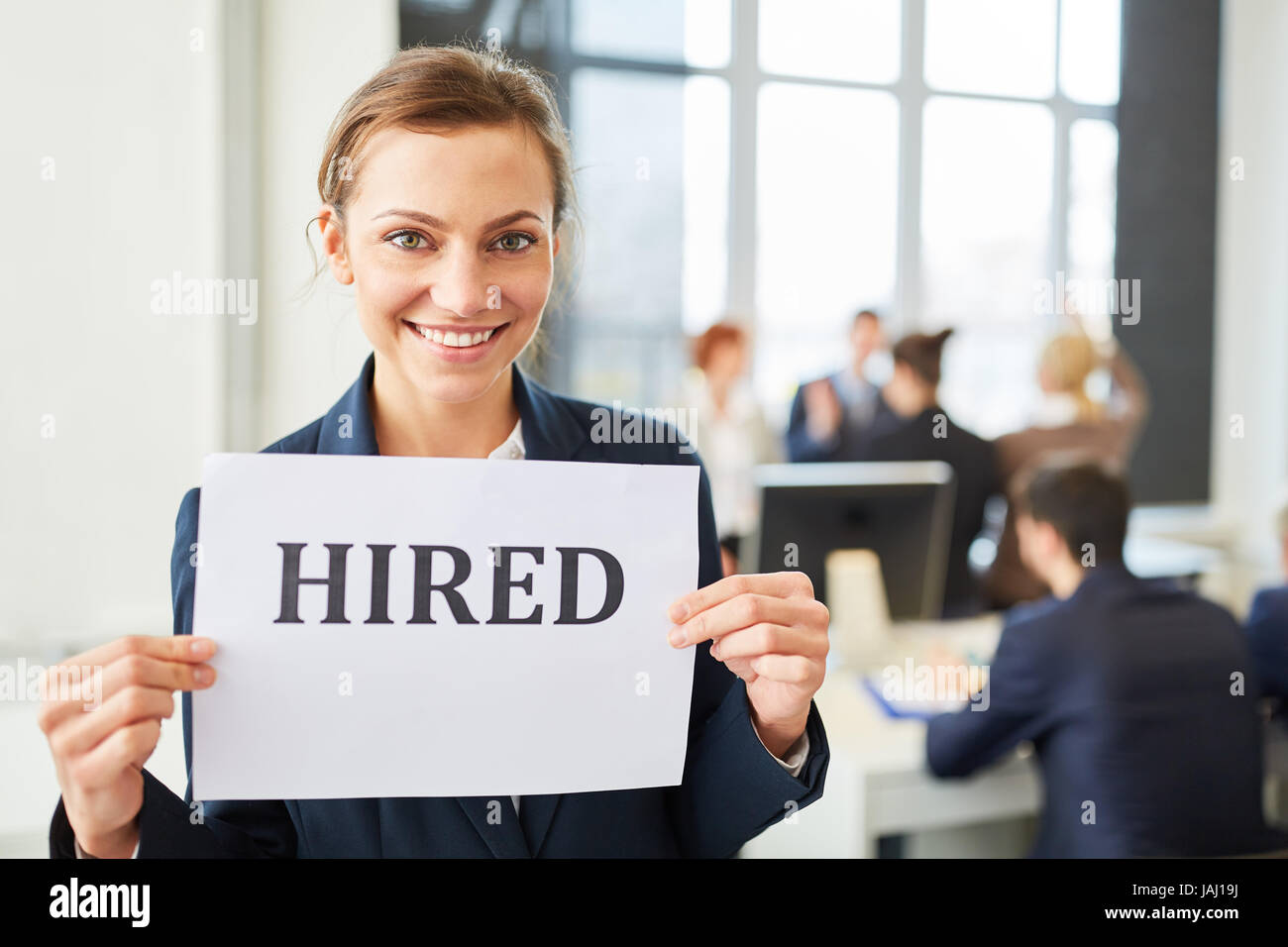 Young successful woman as entrant has new job and holds sign Stock Photo