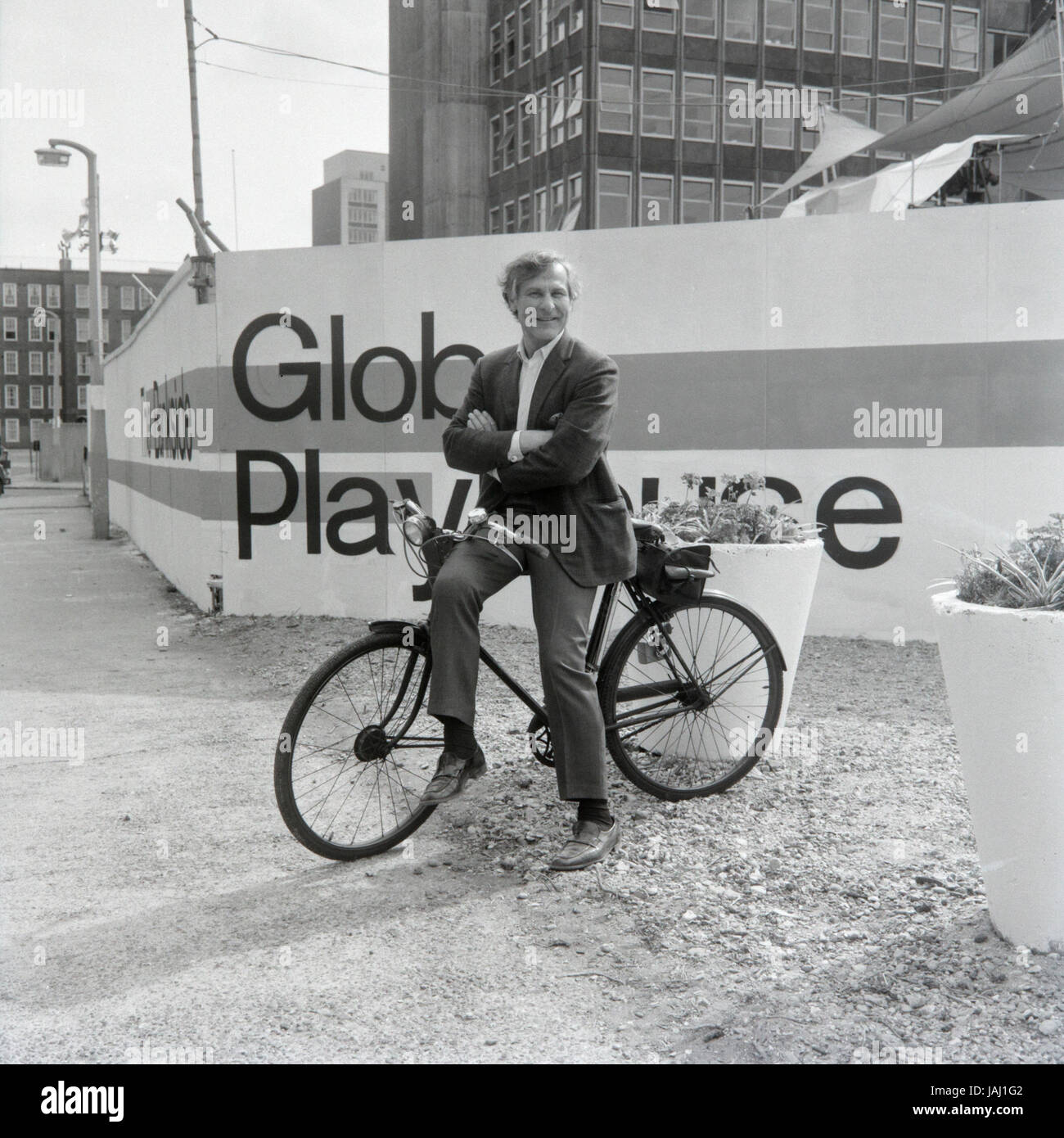 Actor and director Sam Wanamaker on his bicycle outside his proposed site for the Globe Playhouse theatre in London in 1972. The Sam Wanamaker Playhouse is an indoor theatre forming part of Shakespeare's Globe, along with the Globe Theatre on Bankside, London. Built making use of 17th-century plans for an indoor theatre, the playhouse recalls the layout and style of the Blackfriars Theatre, although it is not an exact reconstruction. Its shell was built during the construction of the Shakespeare's Globe complex, notable for the reconstruction of the open-air Globe Theatre of the same period. Stock Photo