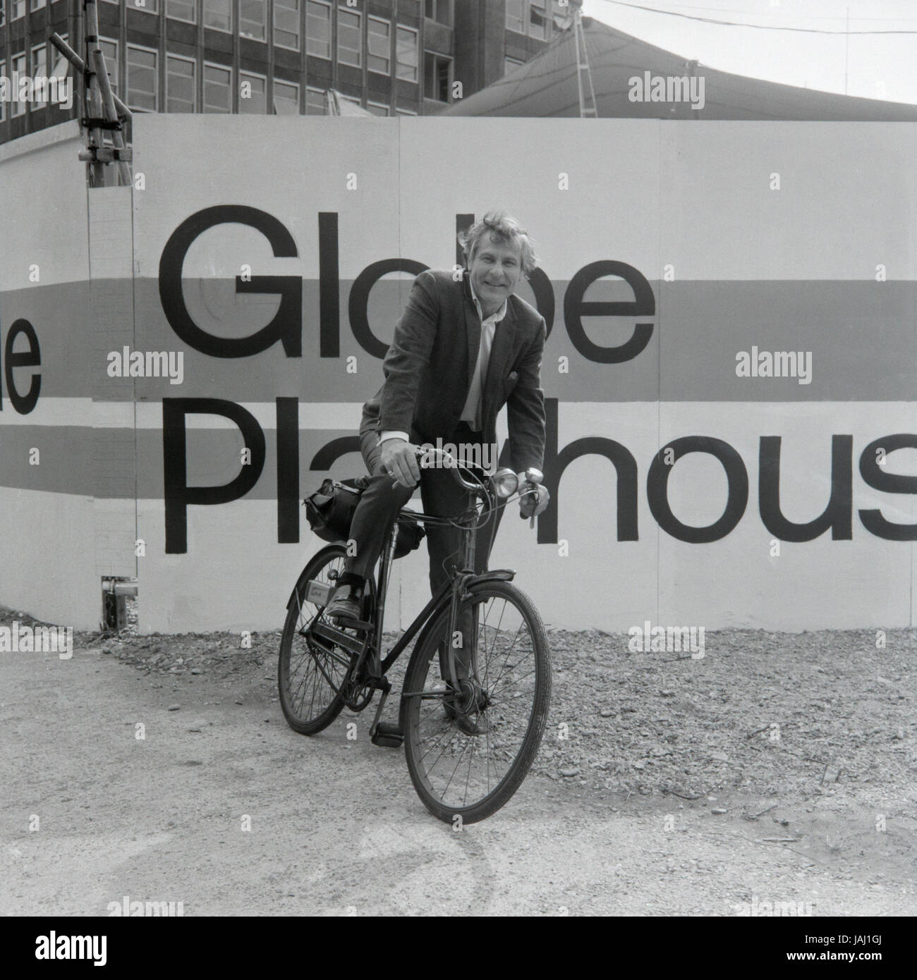 Actor and director Sam Wanamaker on his bicycle outside his proposed site for the Globe Playhouse theatre in London in 1972. The Sam Wanamaker Playhouse is an indoor theatre forming part of Shakespeare's Globe, along with the Globe Theatre on Bankside, London. Built making use of 17th-century plans for an indoor theatre, the playhouse recalls the layout and style of the Blackfriars Theatre, although it is not an exact reconstruction. Its shell was built during the construction of the Shakespeare's Globe complex, notable for the reconstruction of the open-air Globe Theatre of the same period. Stock Photo