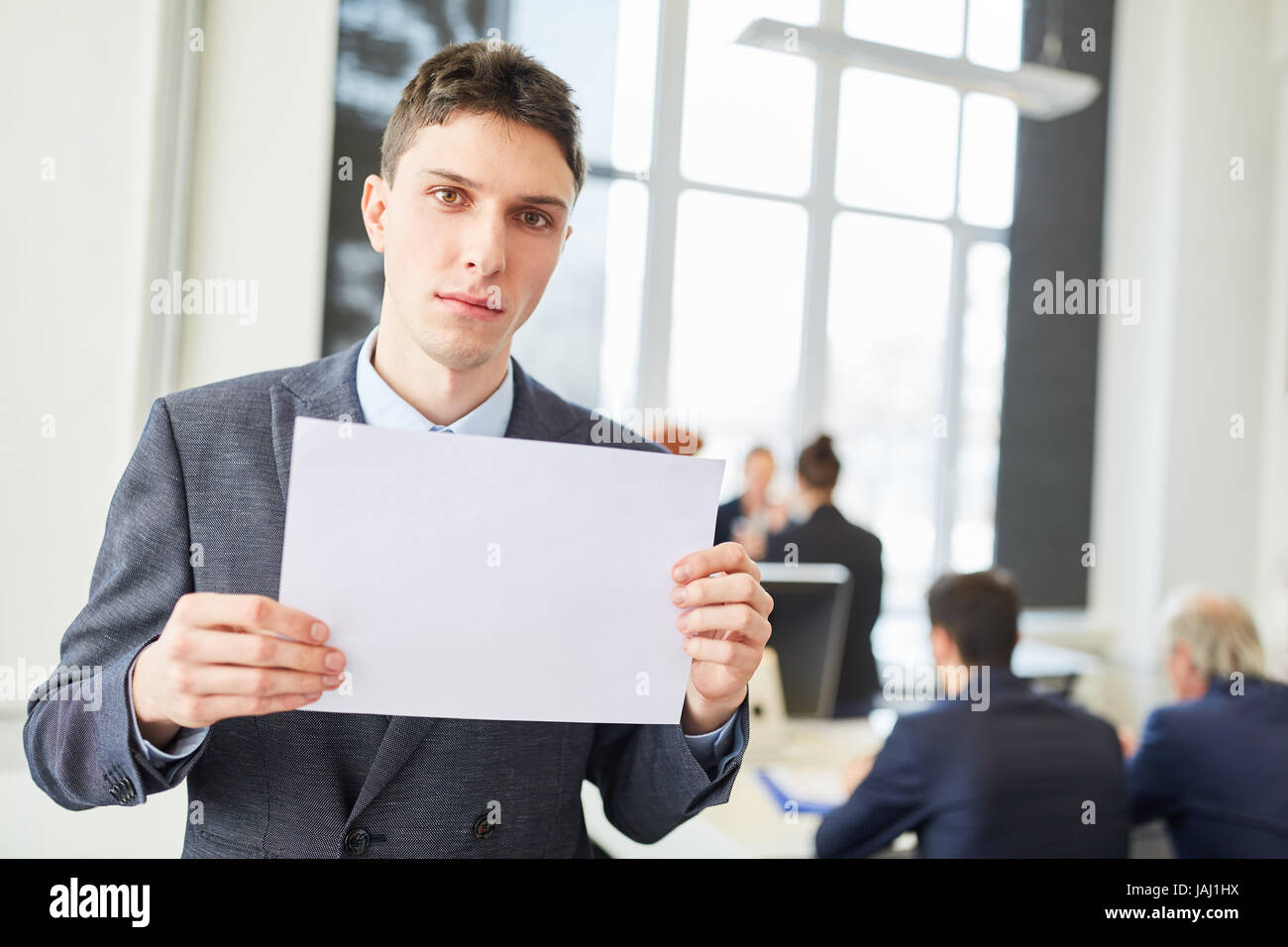 Serious man as candidate holds blank sign in business office Stock Photo