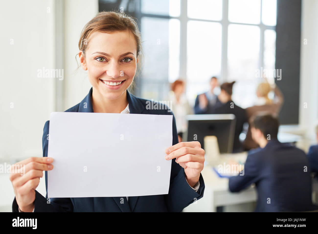 Young businesswoman holds empty sign in office Stock Photo