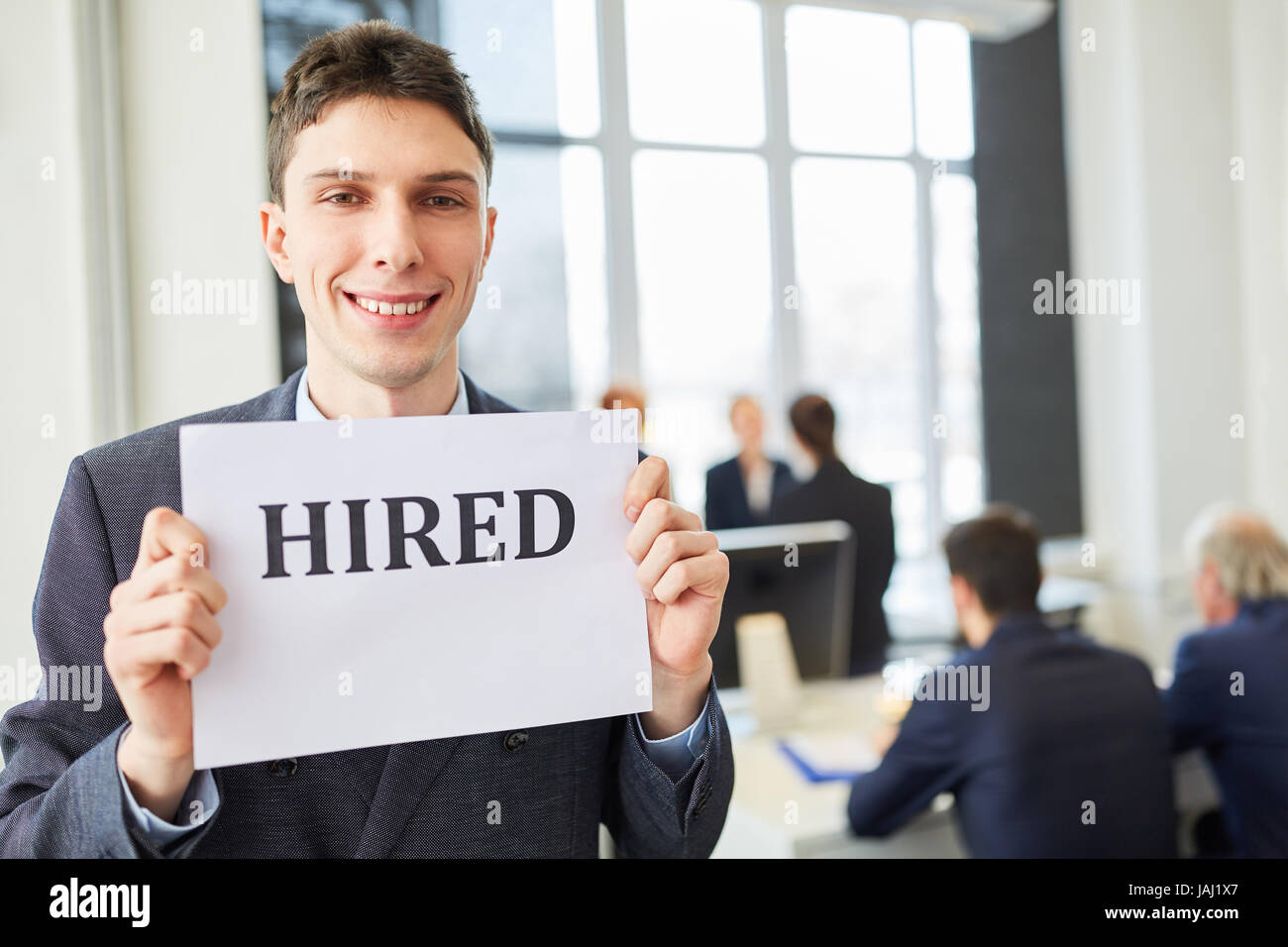 Young man successfuly found a job and holds sign with joy Stock Photo