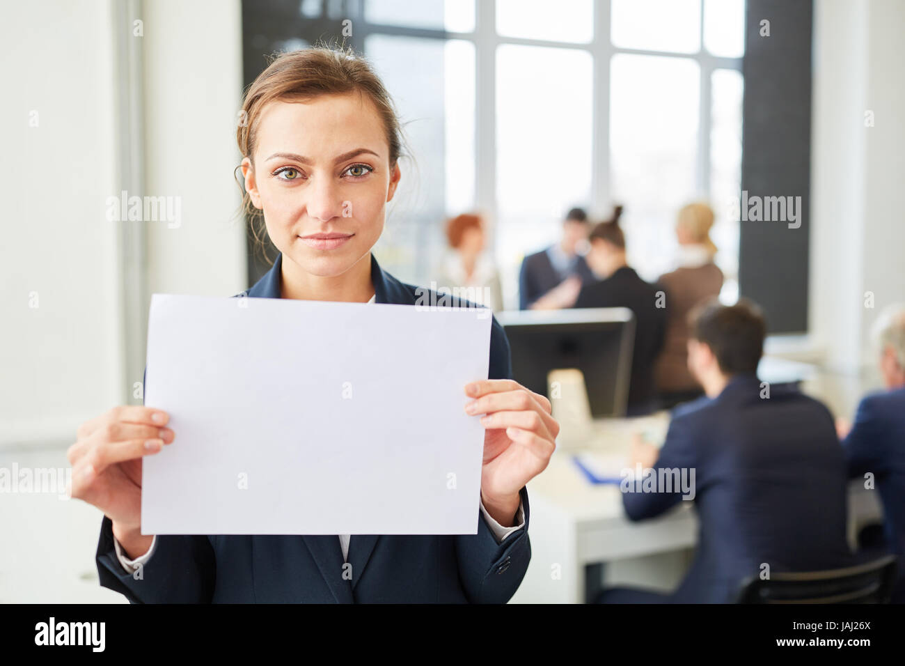 Young business woman holding blank sign in office Stock Photo