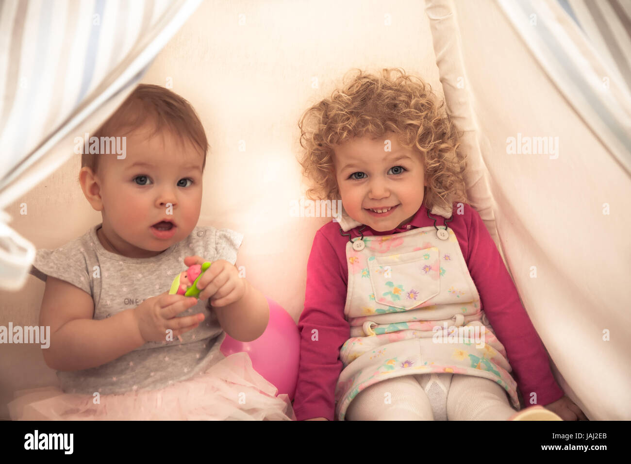 Children playing together in kids rooms in wigwam symbolizing children communication and happy childhood Stock Photo