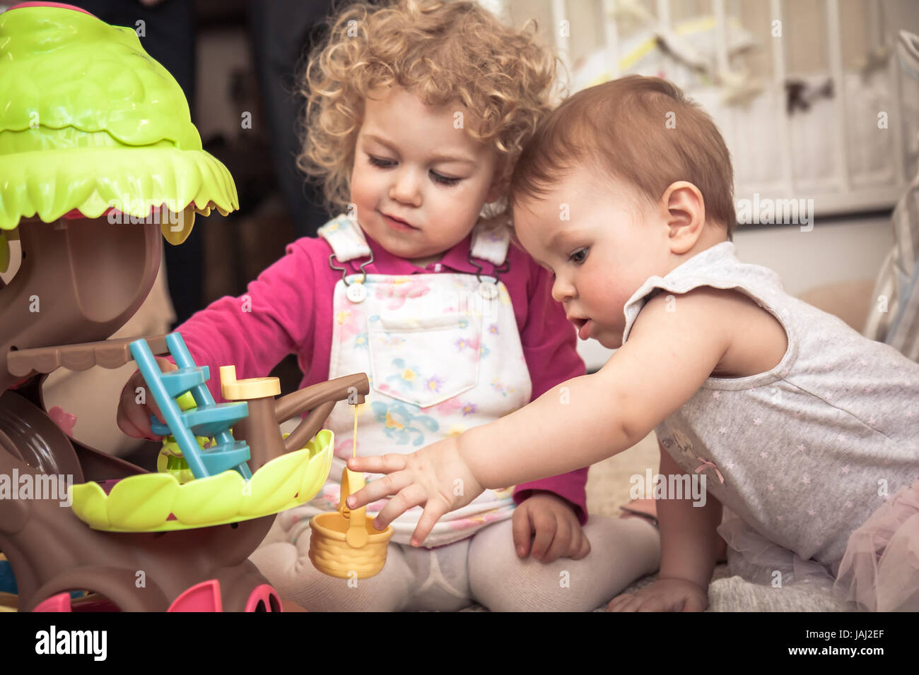 Children playing together in kids rooms with toys symbolizing children communication and happy childhood Stock Photo