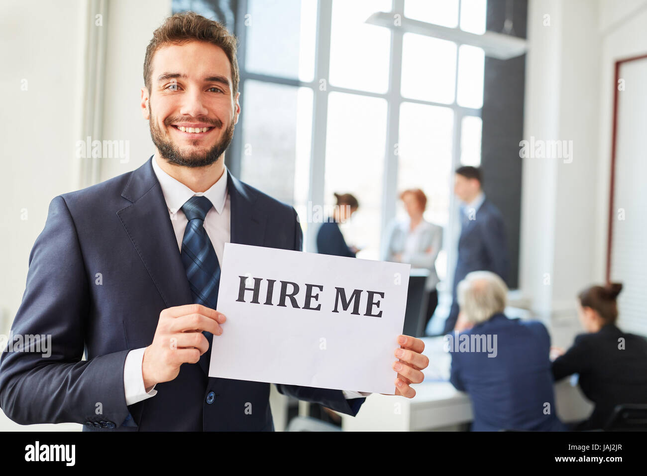 Young business man as job candidate holds sign Stock Photo