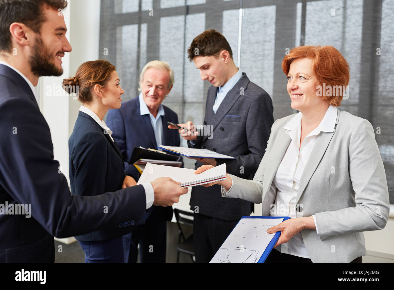 Successful business job candidate in assessment center talkting to staff Stock Photo