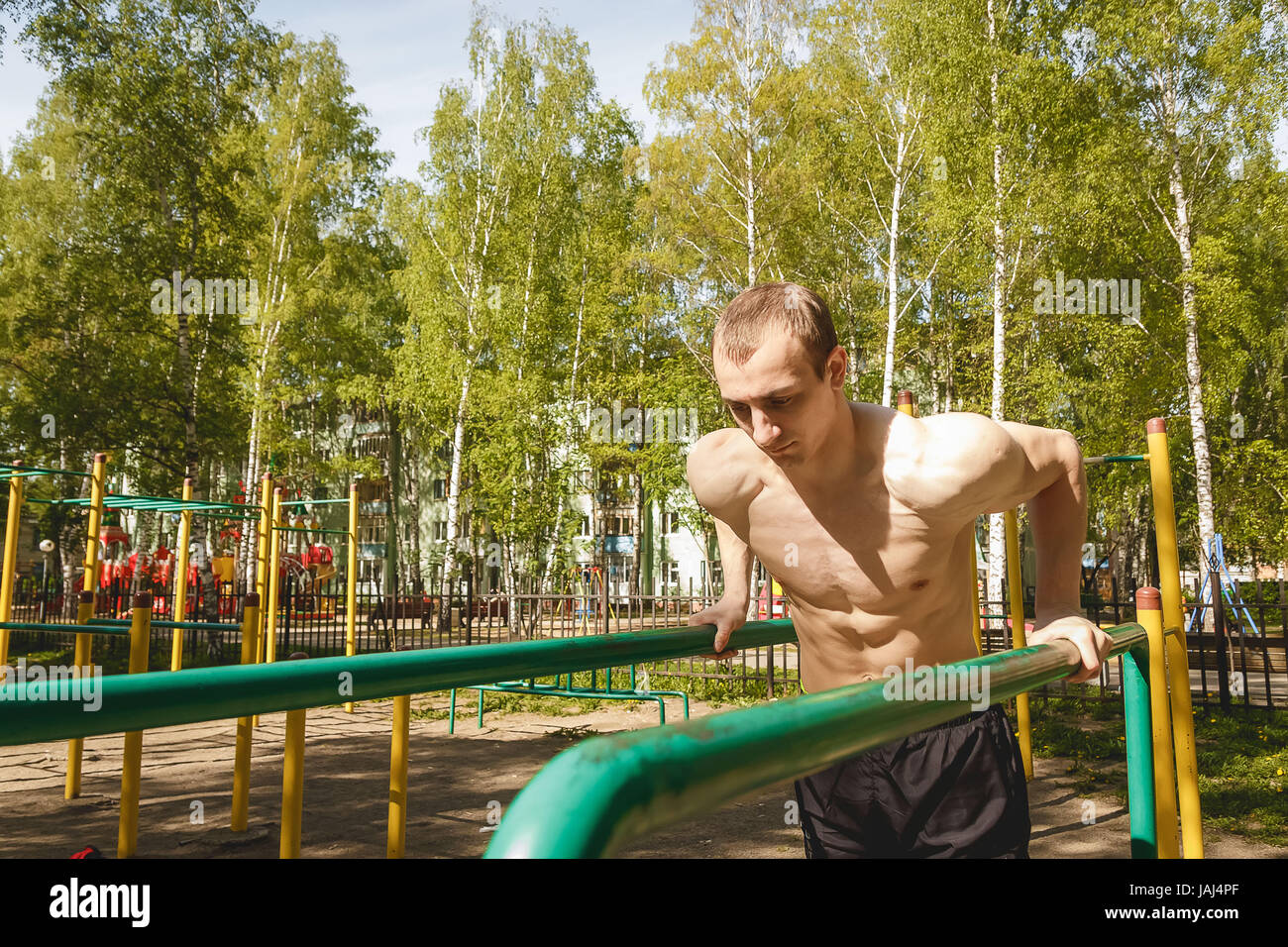 Fitness man at the bar. Exercising outdoors in the Park. Street workout. Stock Photo