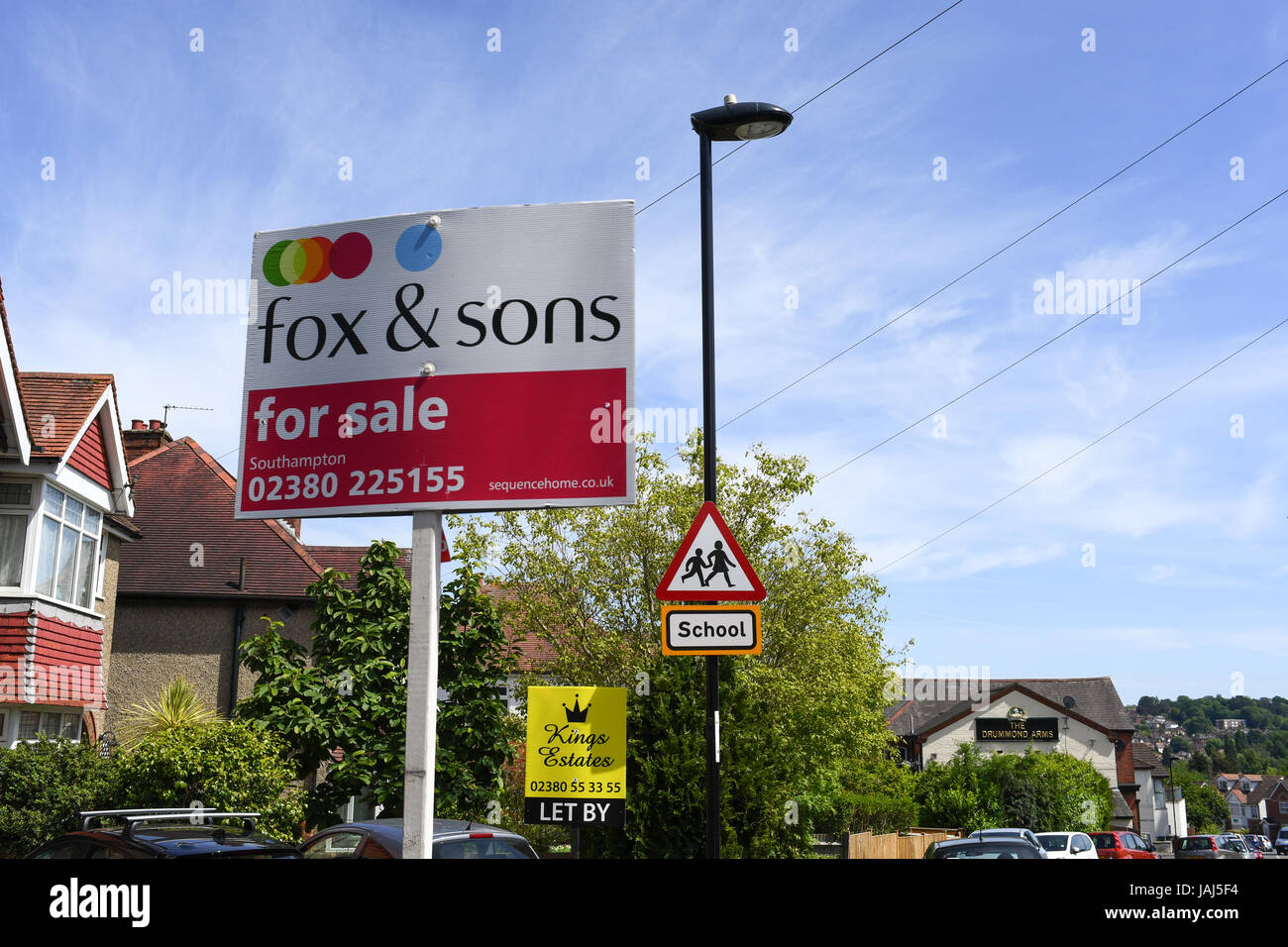 For sale and rental signs next to a school sign Stock Photo