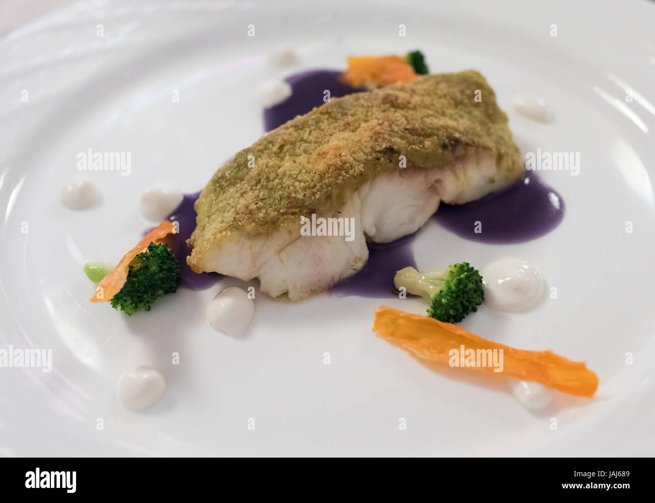 Creative fine dining white fish dish breaded in herbs Stock Photo