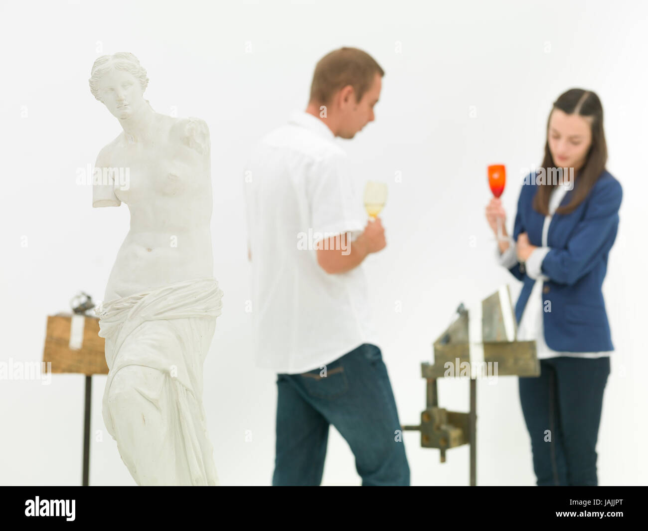 woman and man scrutinizing contemporary sculpture behind a replica of ...