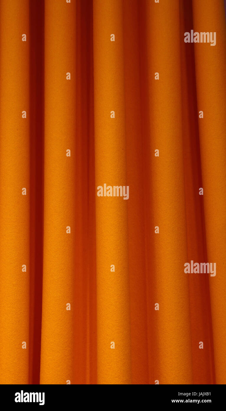 Heavy orange color pleated felt textile curtain background with ...