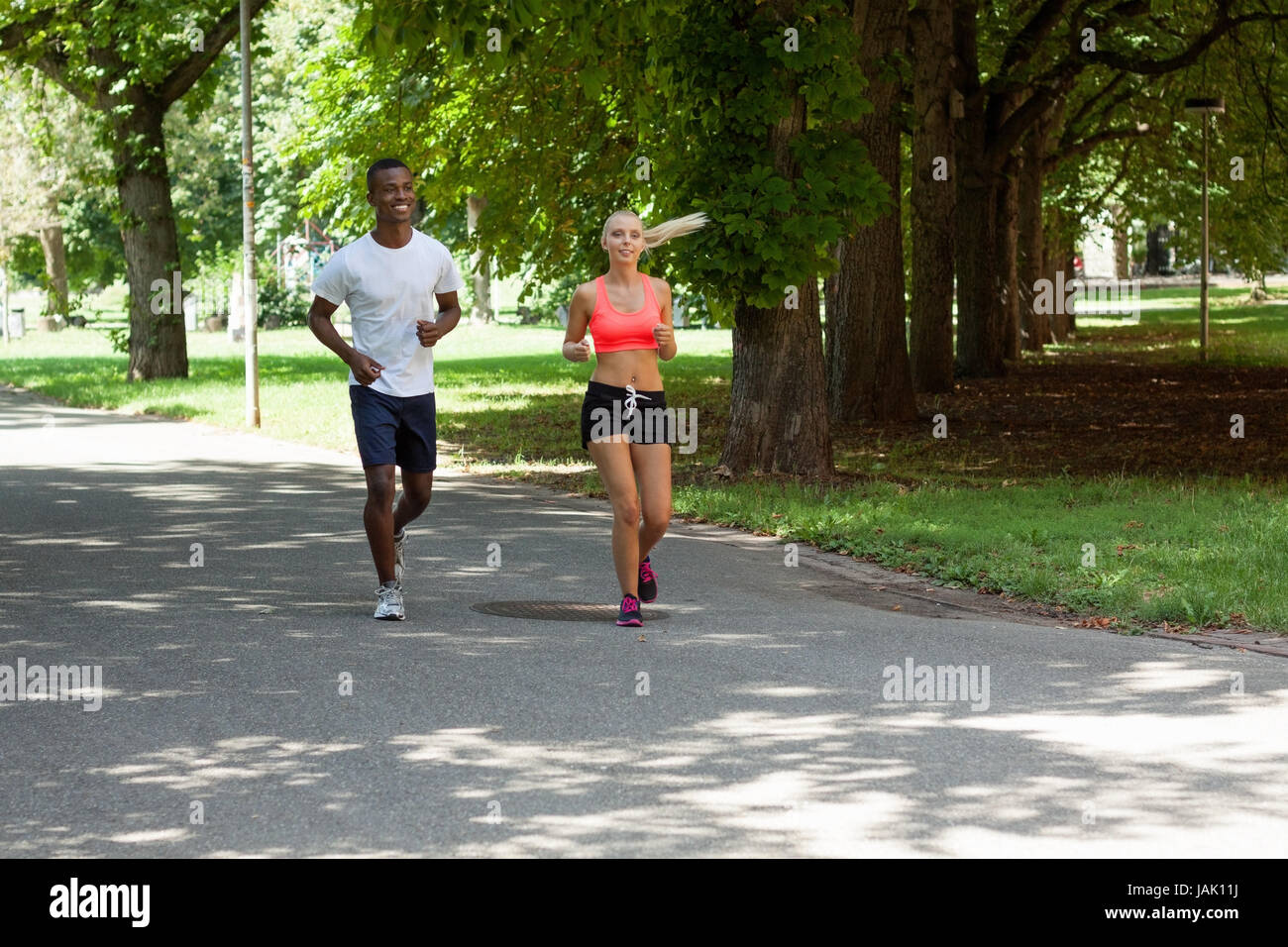 zwei sportliche junge jogger laufend im park im sommer training gesundheit Stock Photo