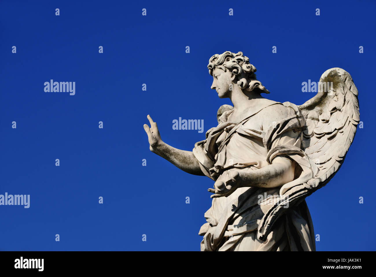 Angel statue holding the Nails of Jesus Cross on Sant'Angelo Bridge in Rome (with blue sky and copy space) Stock Photo